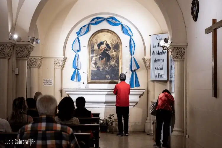 hombre mirando la pintura de la virgen desatuanudos en la parroquia san jose del talar de buenoa aires
