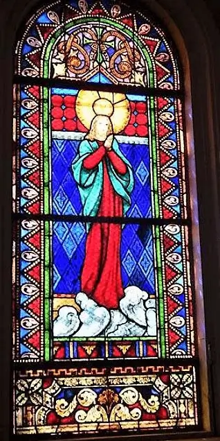 La imagen muestra vitrales de la parroquia Asunción de la Santísima Virgen, que son ventanas de vidrio de colores que representan escenas religiosas