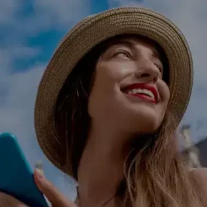 mujer con sombrero y celular en un destino turistico Asistencia al viajero